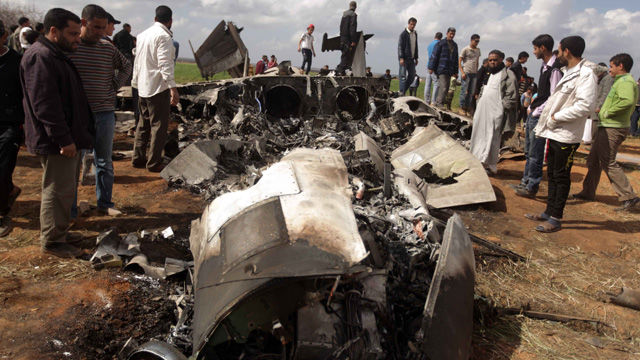 Libios se reúnen alrededor de los restos de un avión de combate F-15 de EE.UU
