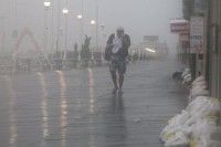Un hombre camina en medio del viento y la lluvia este sábado en la localidad estadounidense de Ocean City, en Maryland, que ha declarado el estado de emergencia por la cercanía del huracán Irene. Foto: AFP