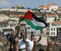 Manifestantes palestinos ondean su bandera durante una protesta por el corte de una carretera por colonos israelíes del asentamiento de Kadumim, en el pueblo de Kfar Kadum en Cisjordania. Foto: AFP