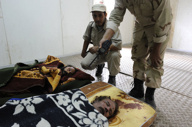 Cuerpos de Muammar al Gaddafi y su hijo Mutassim. Foto: PHILIPPE DESMAZES / AFP