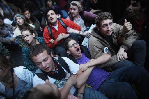 Manifestantes asociados al movimiento 'Occupy Wall Street' se encaran este viernes a la policía, cuando intentó desalojarlos del parque de Nueva York en el que acampan desde el 17 de septiembre. Foto: AFP