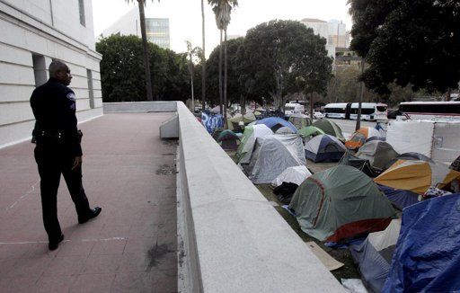 Un policía vigila el campamento en el exterior del Ayuntamiento de Los Angeles, California. Foto: AP/Jae C. Hong, Archivo
